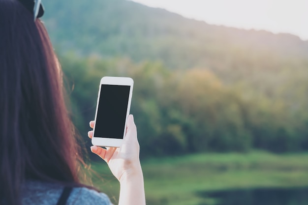 Mano de personas usando teléfono inteligente maqueta en al aire libre