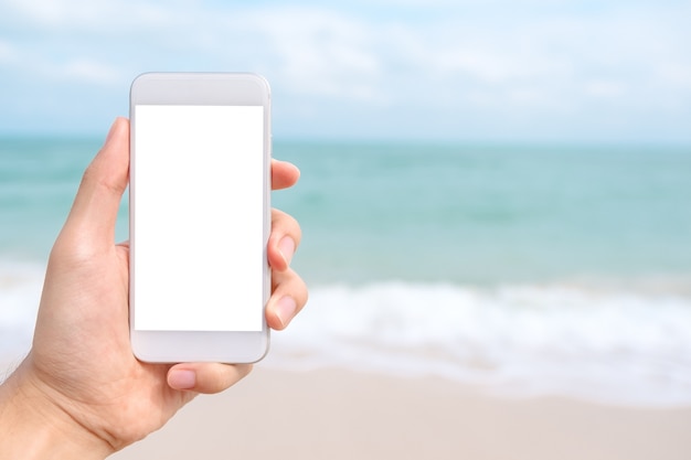 Mano de personas usando teléfono inteligente maqueta por mar