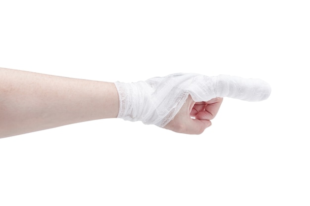 Mano de piel blanca con el dedo índice vendado en gesto de señalar y muñeca, aislado en superficie blanca.