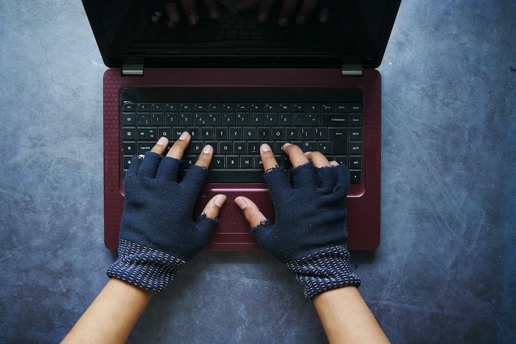Foto mano de pirata informático robando datos de la computadora portátil de arriba hacia abajo