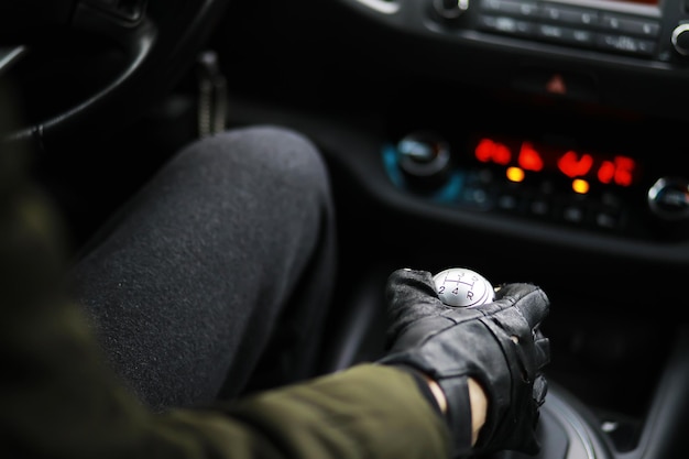 Mano en el pomo de la palanca de cambios del coche. El conductor cambia la velocidad en el coche. Mano en la palanca de cambios.