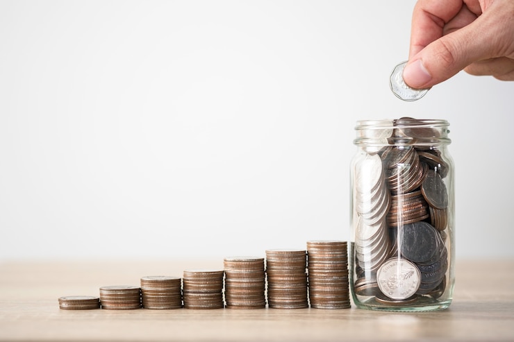Foto mano poniendo monedas para guardar el tarro y el apilamiento de monedas. concepto de ganancias y dividendos de inversión de ahorro de dinero.