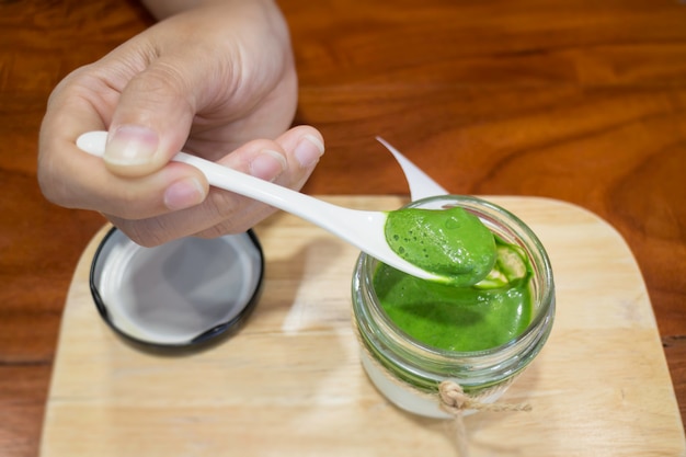 Mano en el postre de mousse de té verde matcha