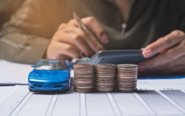 Mano presionando el botón calculadora con seguro de coche y concepto de servicios de coche