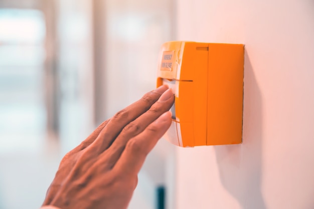 La mano del primer es empujar el interruptor de emergencia para abrir la puerta en la salida de incendios del edificio