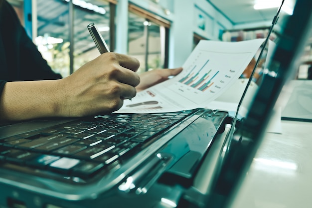 Mano del primer de las mujeres de negocios con la escritura de papel en el gráfico.