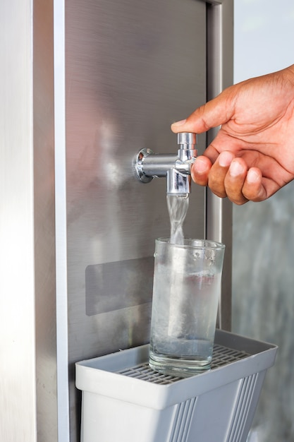 Foto la mano puso el refrigerador bebe el agua