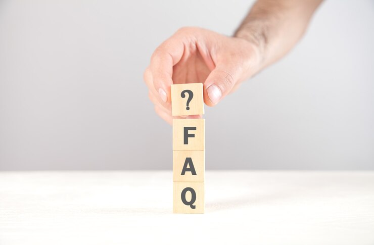 Foto mano que muestra el signo de interrogación con una palabra de preguntas frecuentes en cubos.