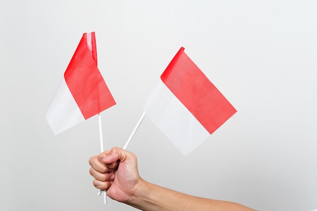 Mano que sostiene el atributo rojo y blanco de la bandera de Indonesia Concepto del día de la independencia