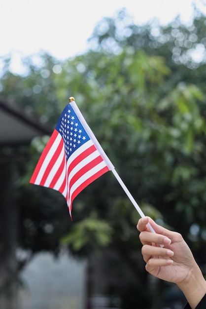 Mano que sostiene la bandera americana al aire libre