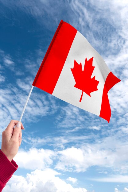 Mano que sostiene la bandera canadiense al aire libre