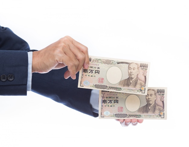 Mano que sostiene el billete de banco japonés en el fondo blanco. Dinero japonés