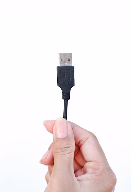 Mano que sostiene el cable USB en el fondo blanco