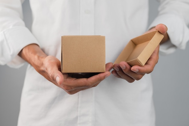 Foto mano que sostiene la caja de regalo, caja de regalo de año nuevo, caja de regalo de navidad, espacio de copia. navidad, año nuevo, concepto de cumpleaños.