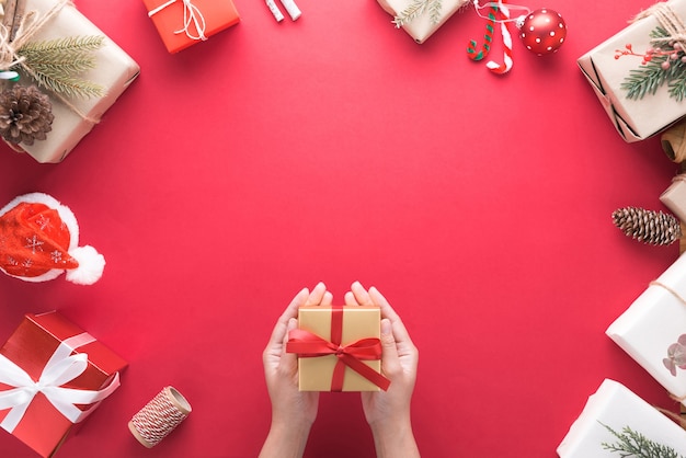 Mano que sostiene la caja de regalo con motivo de la decoración Feliz Navidad y Feliz Año Nuevo