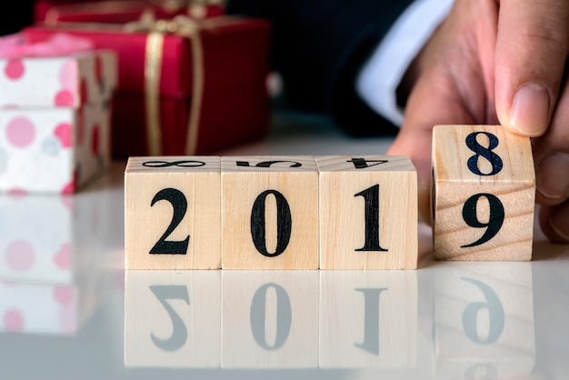 Mano que sostiene el calendario de cubos de madera con número 2019, feliz año nuevo concepto 2019.