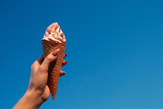 mano que sostiene el cono de helado. concepto foto mujer mantenga helado