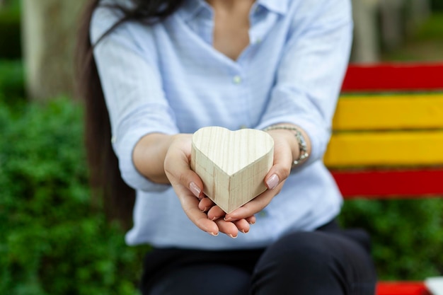 Mano que sostiene el corazón en el parque