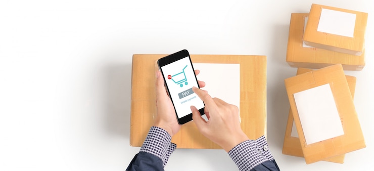Foto mano que sostiene el dispositivo de teléfono inteligente y pantalla táctil, propietario de negocio trabajando. compras en línea pyme emprendedor