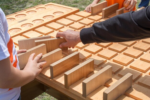 Mano que sostiene el elemento del rompecabezas de madera en la mano