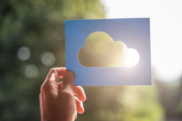 Foto mano que sostiene el símbolo de computación en la nube