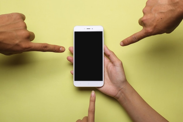 Foto la mano que sostiene un teléfono inteligente apunta con otro dedo. concepto de compras en línea.