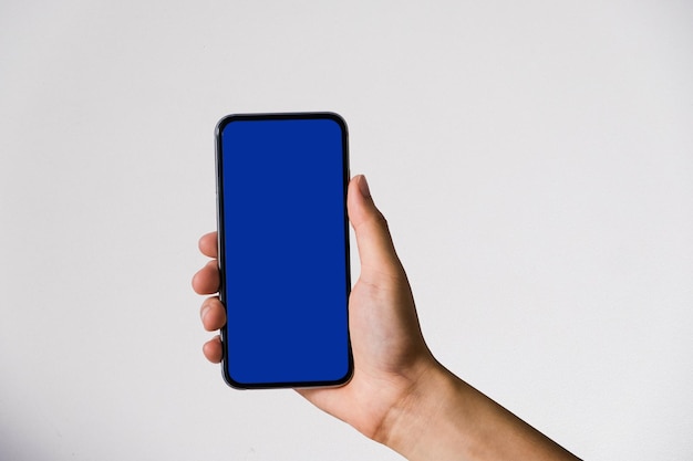 Mano que sostiene el teléfono inteligente en blanco con pantalla azul egipcia en fondo blanco