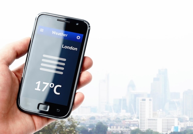 Mano que sostiene el teléfono inteligente con el clima en Londres