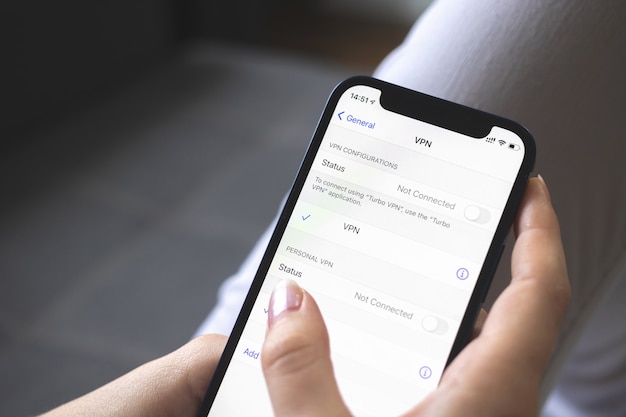 Mano que sostiene el teléfono móvil con configuración de VPN en la vista de primer plano de la pantalla