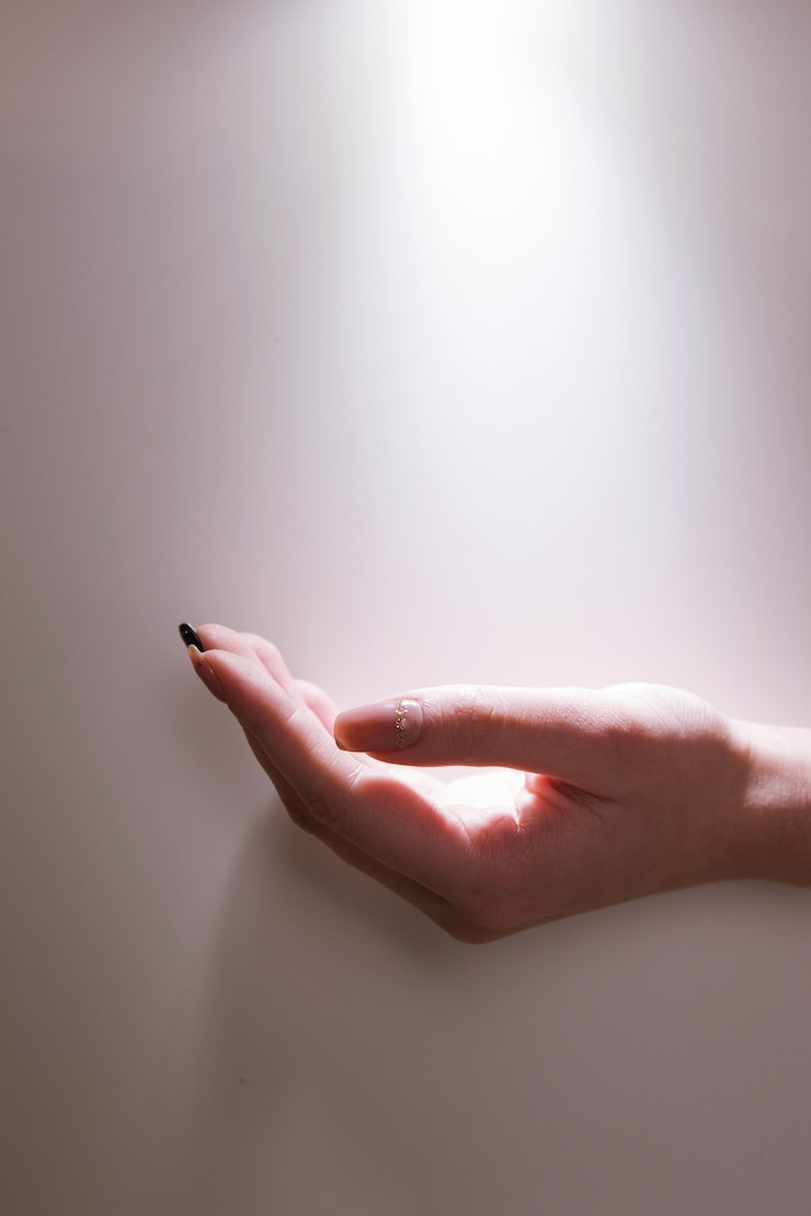 Foto mano bajo los rayos de luz sagrada. fe de oración. esperando un milagro