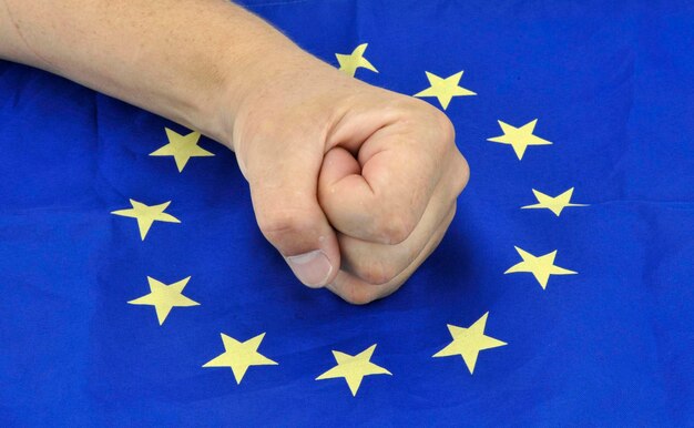 Mano recortada en la bandera de la Unión Europea