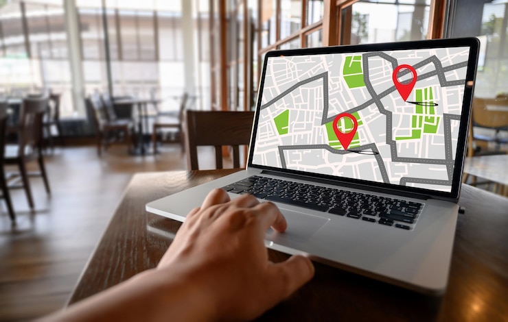 Foto mano recortada buscando gps en la computadora portátil en el café