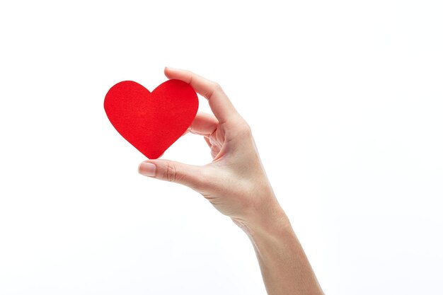 Foto mano recortada con forma de corazón rojo contra un fondo blanco