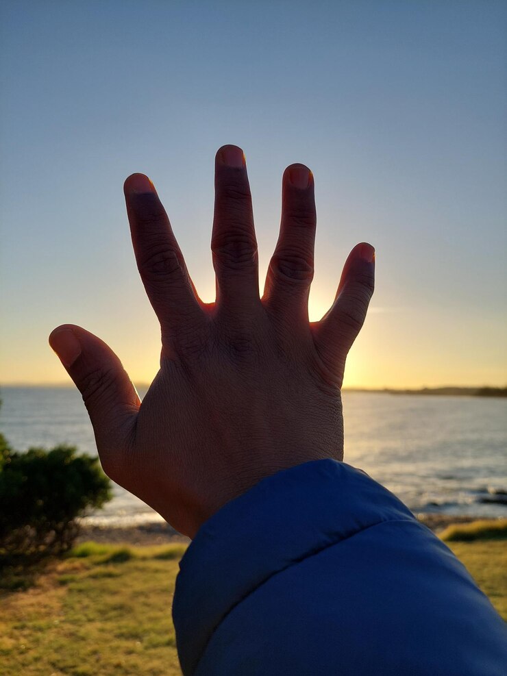 Foto mano recortada haciendo gestos contra la pared