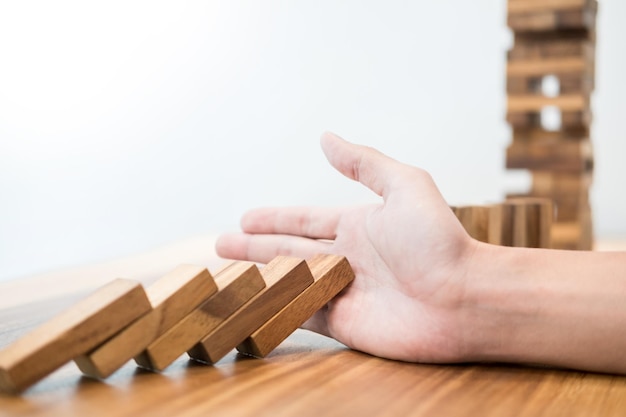 Foto mano recortada jugando con bloques de juguete de madera contra un fondo blanco