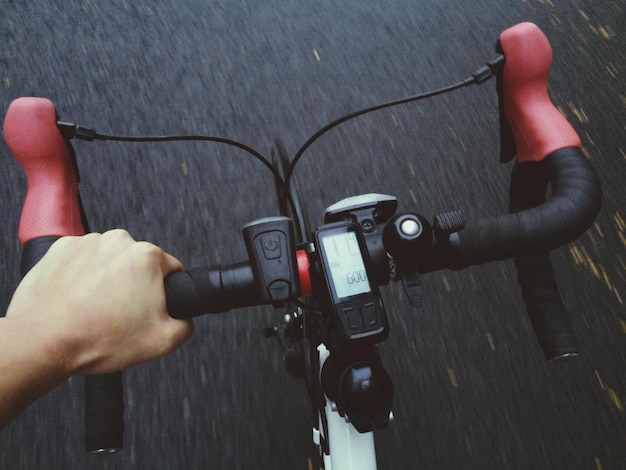 Mano recortada montando en bicicleta en la carretera