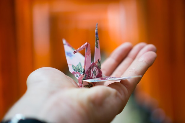 Foto mano recortada con origami en la mano