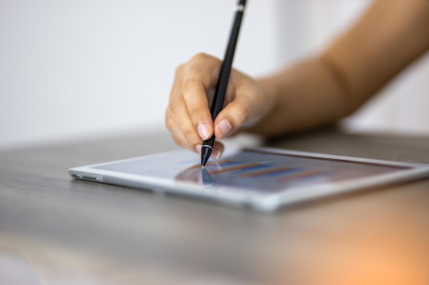 Mano recortada de una persona de negocios usando una tableta digital en la mesa