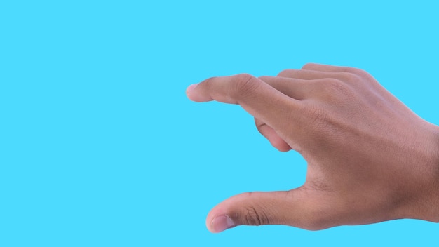 Mano recortada de una persona que hace gestos contra un fondo azul
