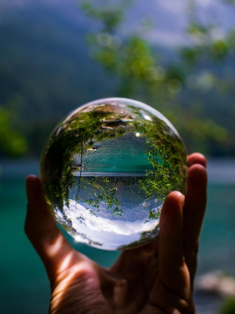 Foto mano recortada de una persona que sostiene una bola de cristal