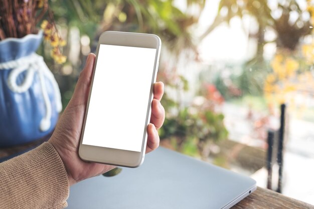 Foto mano recortada de una persona que sostiene un teléfono móvil