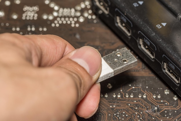 La mano recortada que sostiene el cable USB