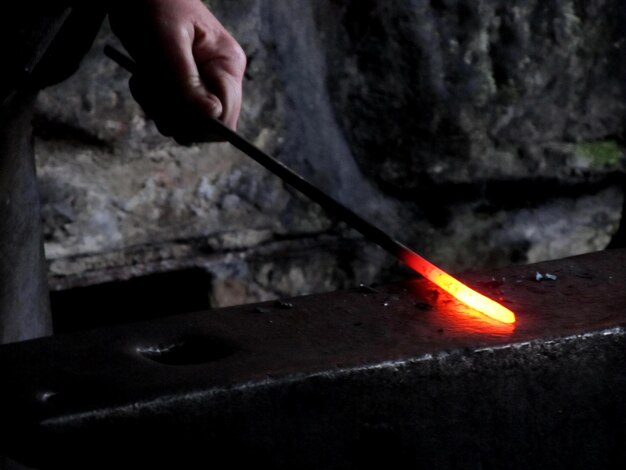 Foto mano recortada sosteniendo metal en el taller