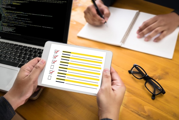 Mano recortada sosteniendo una tableta digital en el escritorio