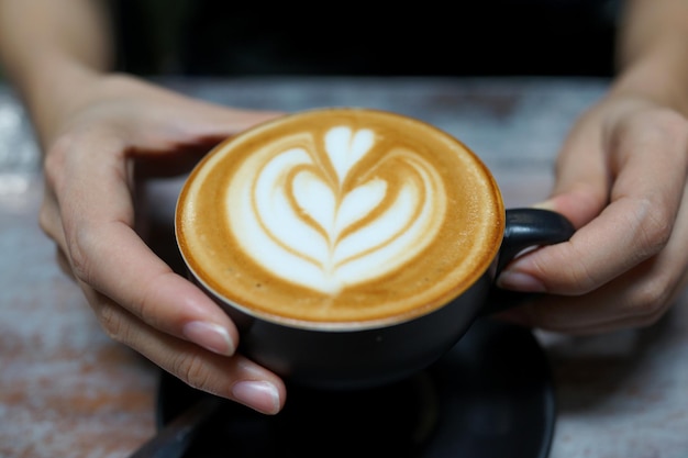 Mano recortada sosteniendo una taza de café