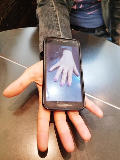 Foto mano recortada sosteniendo un teléfono inteligente con fotografía