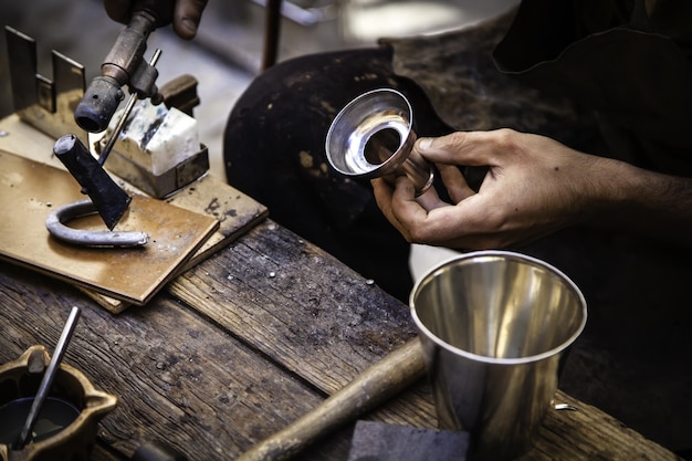 Foto mano recortada de un trabajador masculino sosteniendo metal en un taller