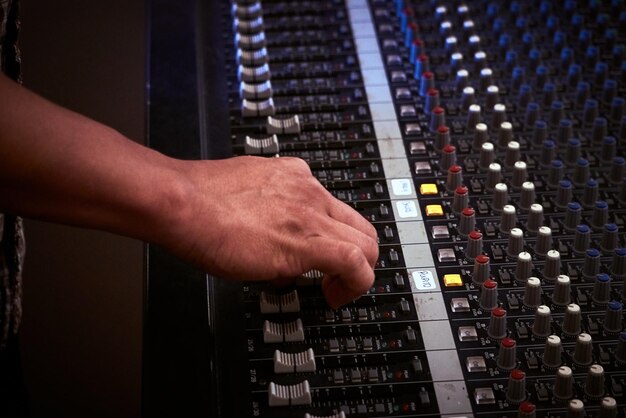 Foto mano recortada usando mezclador de sonido en el estudio