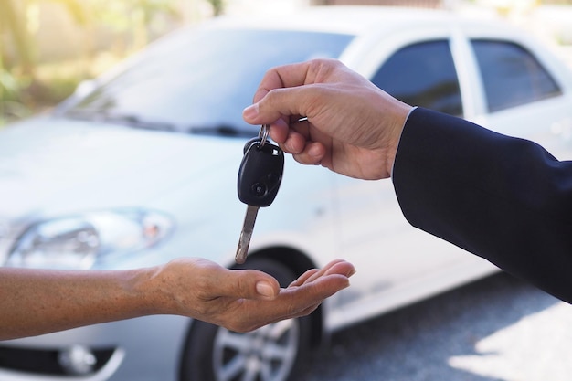 Mano recortada del vendedor dando la llave del coche al cliente