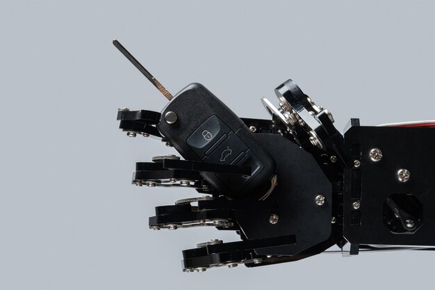 Mano robótica real con llave de coche negro Concepto de inteligencia artificial en la industria del transporte